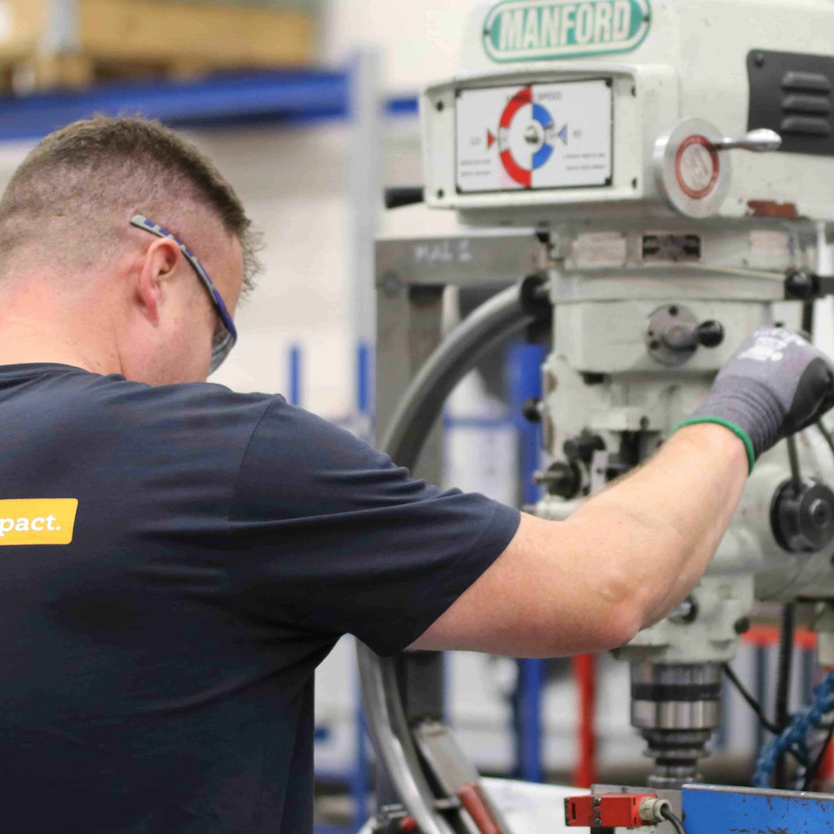 Worker operating industrial Manford machine in factory setting