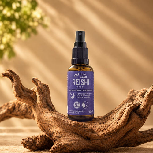 Flacon spray en verre ambré 30 ml de Reishi Pure Croft avec embout pulvérisateur noir, posé sur du bois flotté naturel, formule routine nocturne au zeste d'orange.